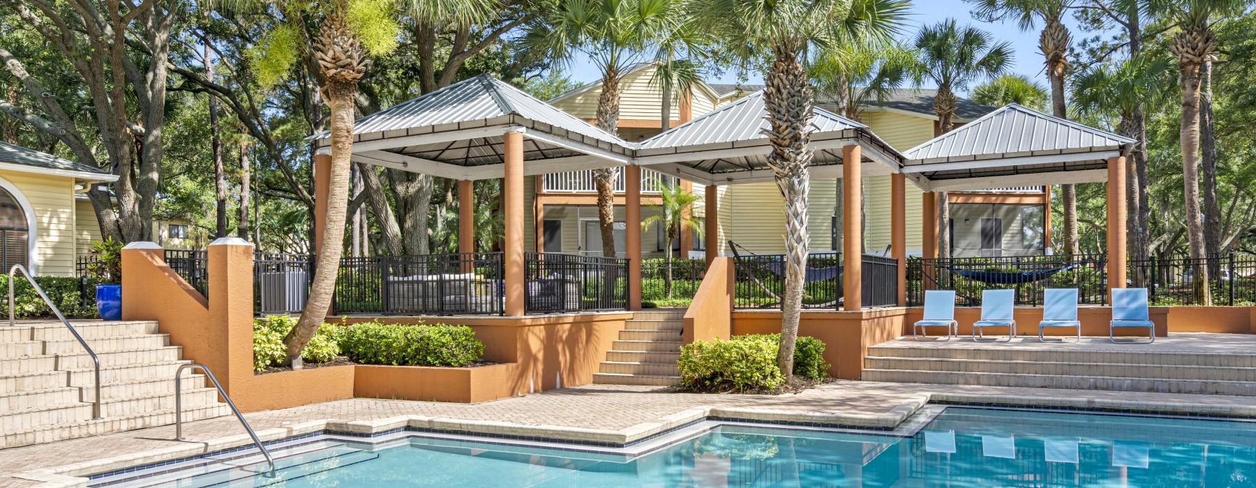 a pool with a gazebo and trees around it