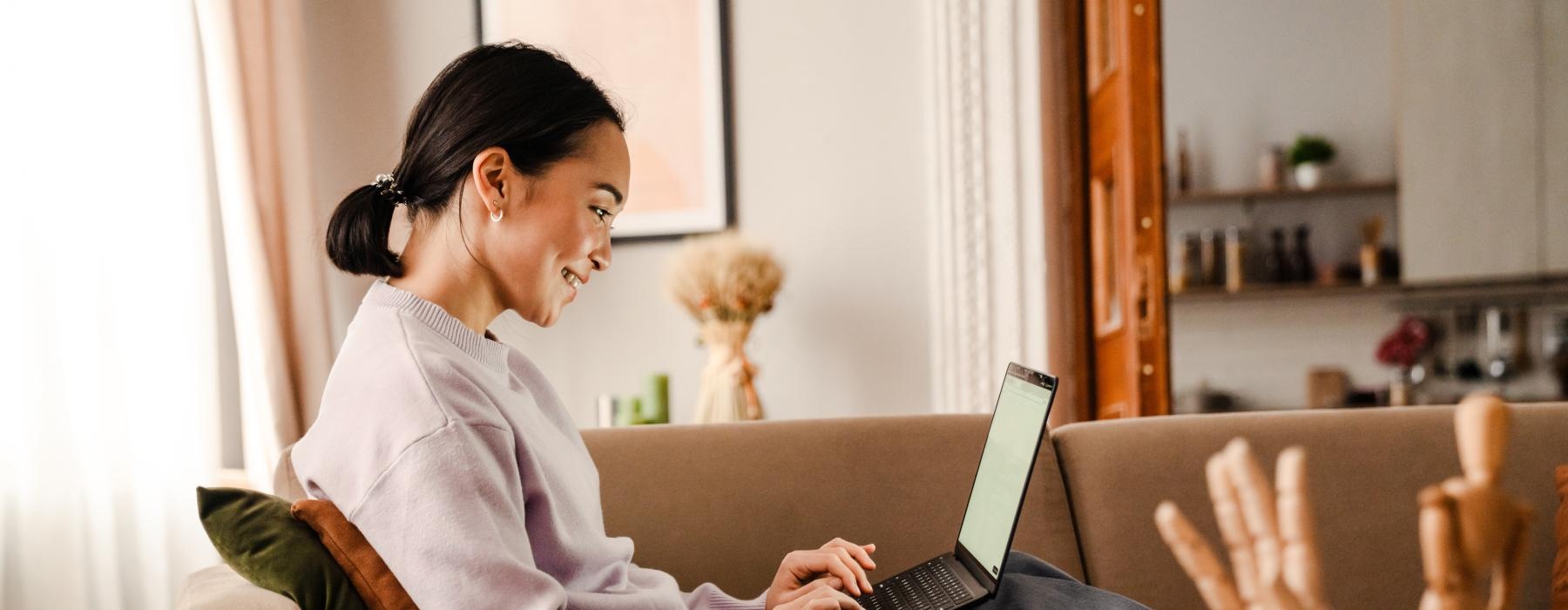 a person sitting on a couch using a laptop